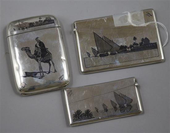 Two continental white metal and niello card cases and a similar cigarette case.